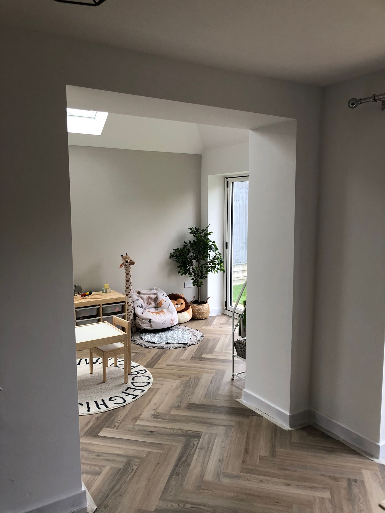 View through the new structural opening into the finished playroom — Huxley Close garage conversion